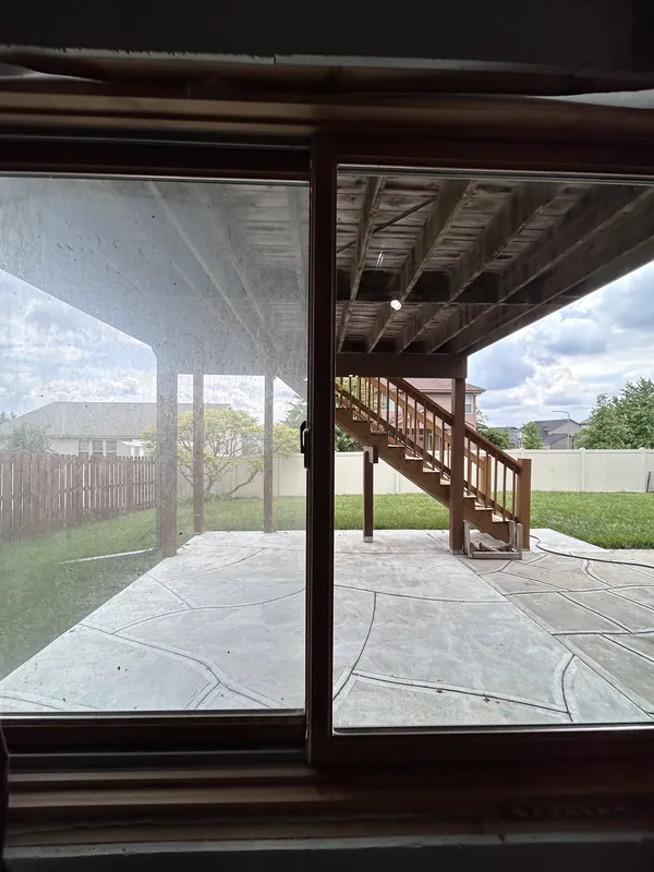 Sliding patio door half cleaned, dirty pane next to spotless pane